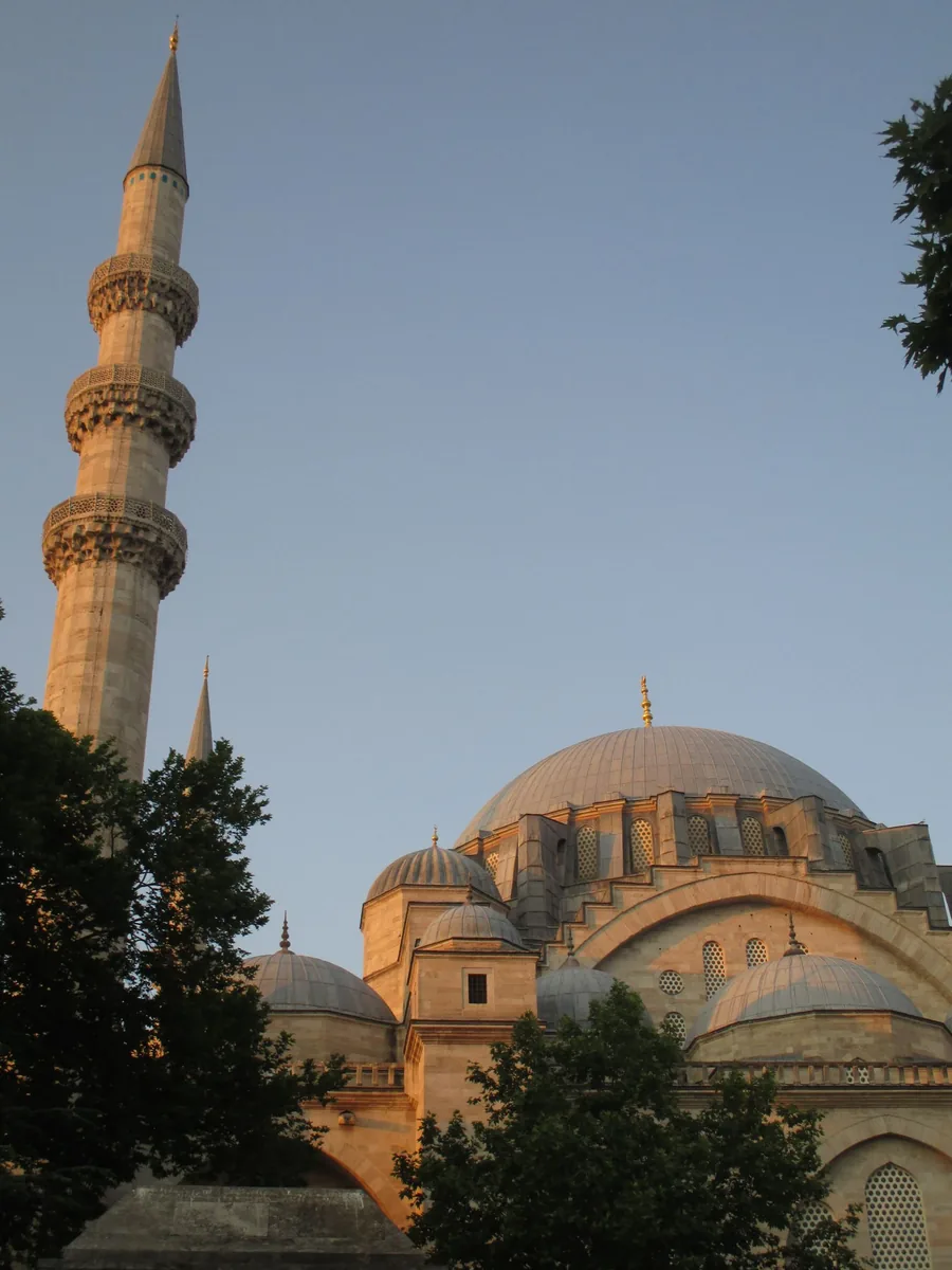 Foto menara dan kubah Masjid Süleymaniye saat senja